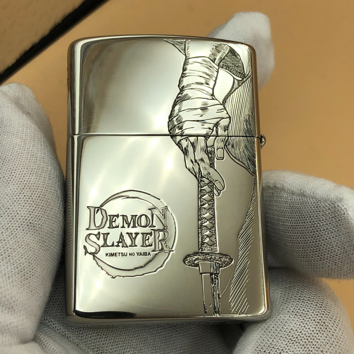 Engraved Demon Slayer Zippo-style lighter featuring hand holding katana sword, anime collectible gift